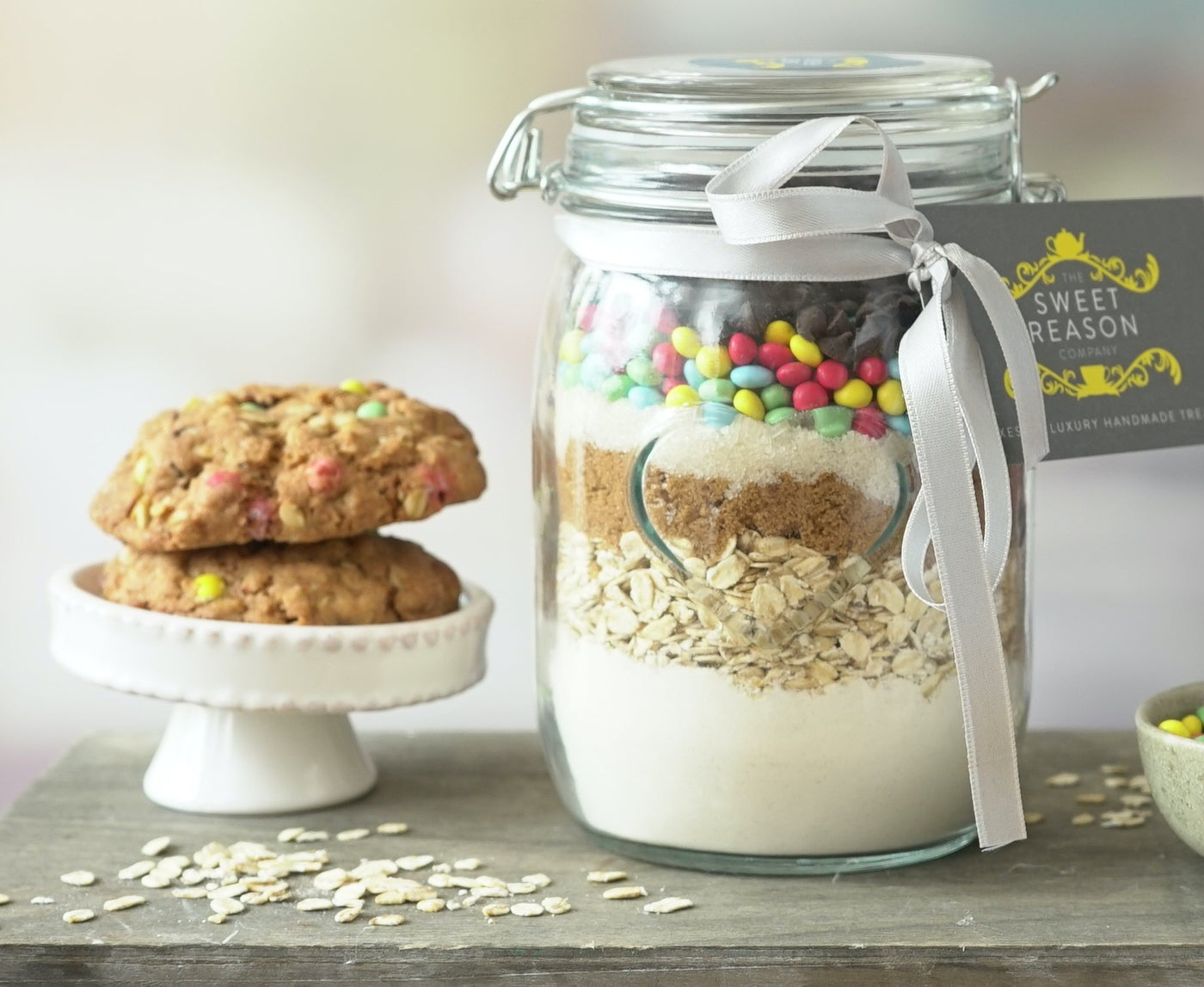 Baking mix cookie jar filled with baking ingredients. Freshly made cookies stacked to the side. 
